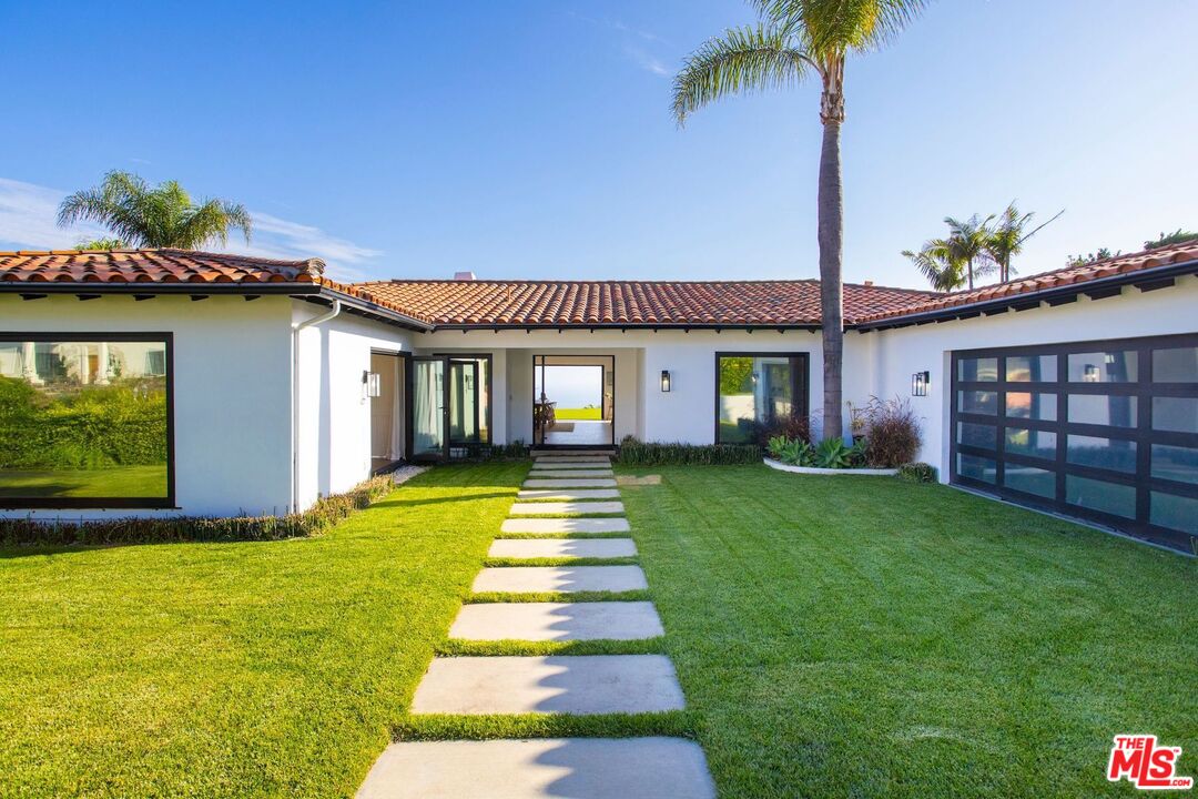 a front view of a house with a garden and yard