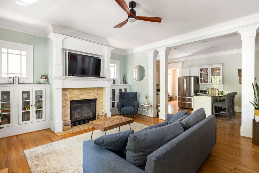 a living room with furniture a flat screen tv and a fireplace