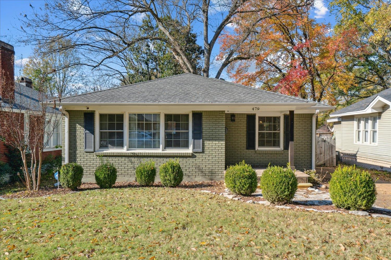 a front view of a house with a yard and potted plants