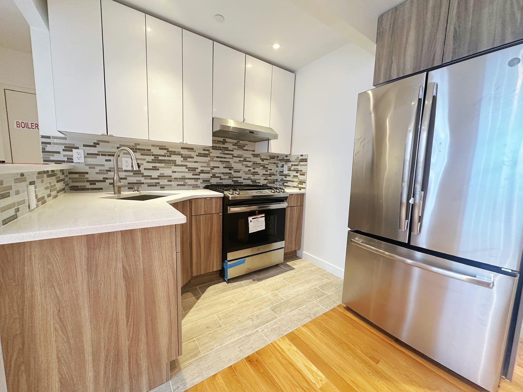 Kitchen with tasteful backsplash, white cabinetry, sink, and appliances with stainless steel finishes