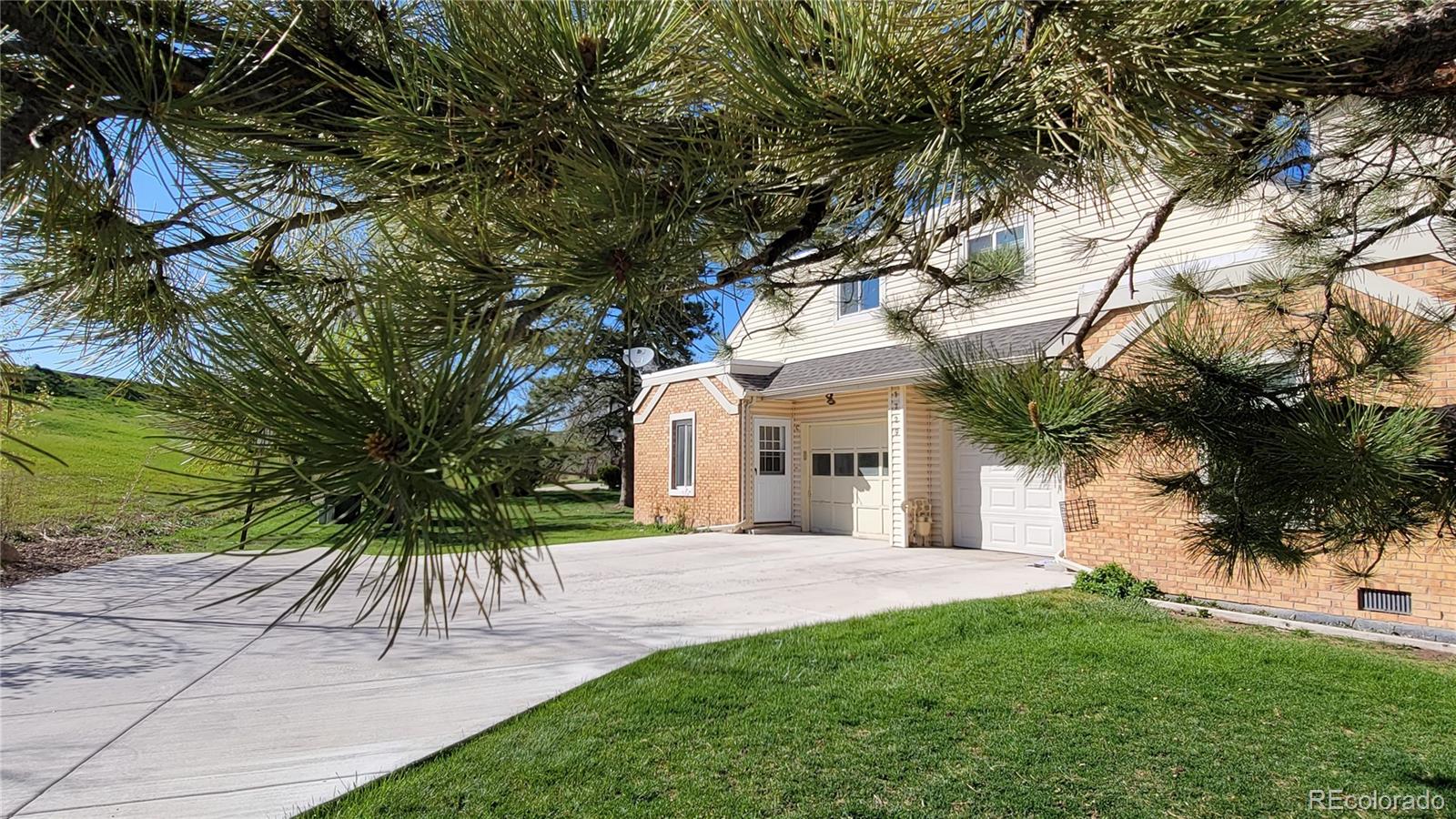 a front view of a house with a tree and a yard