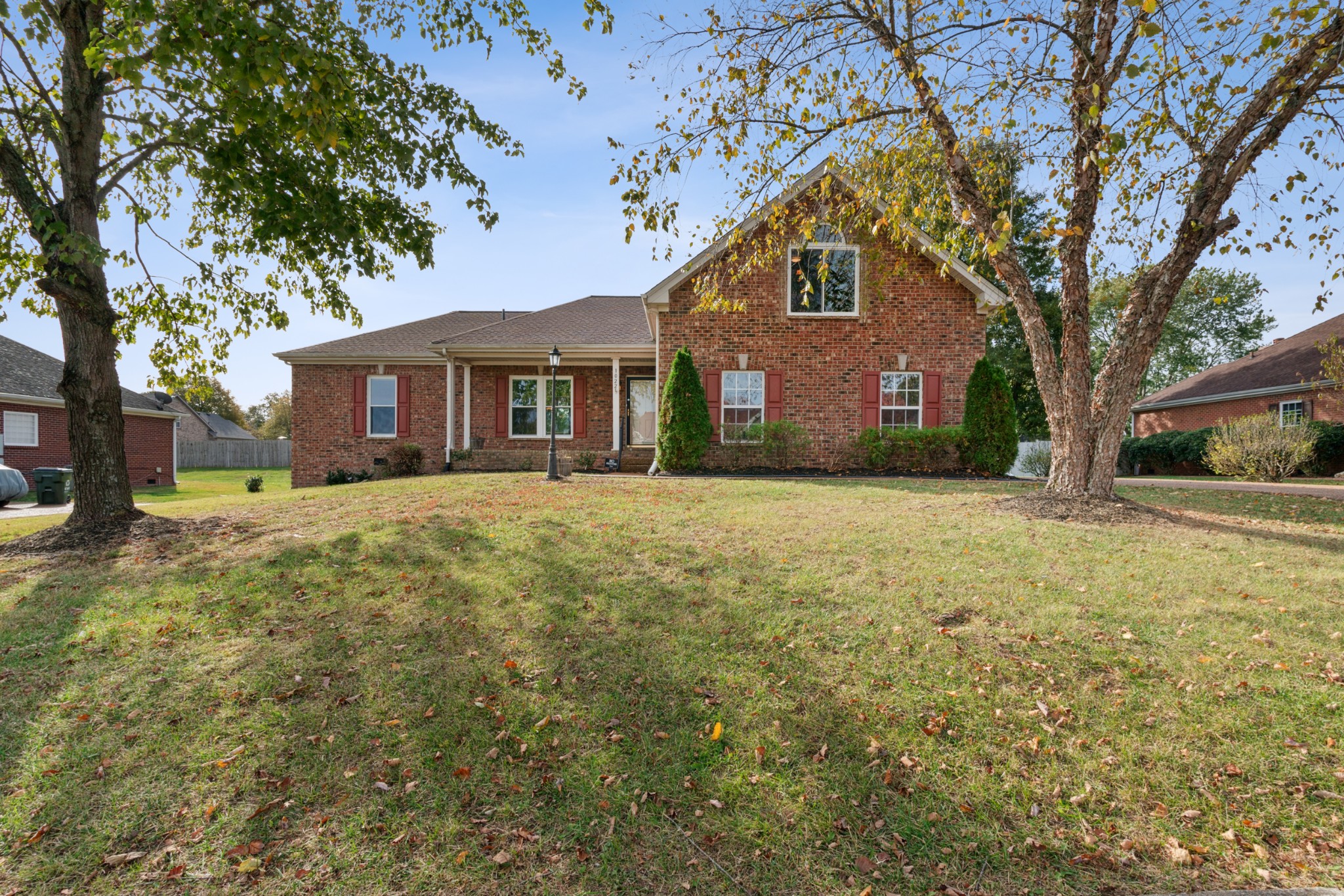 a front view of house with yard and trees around