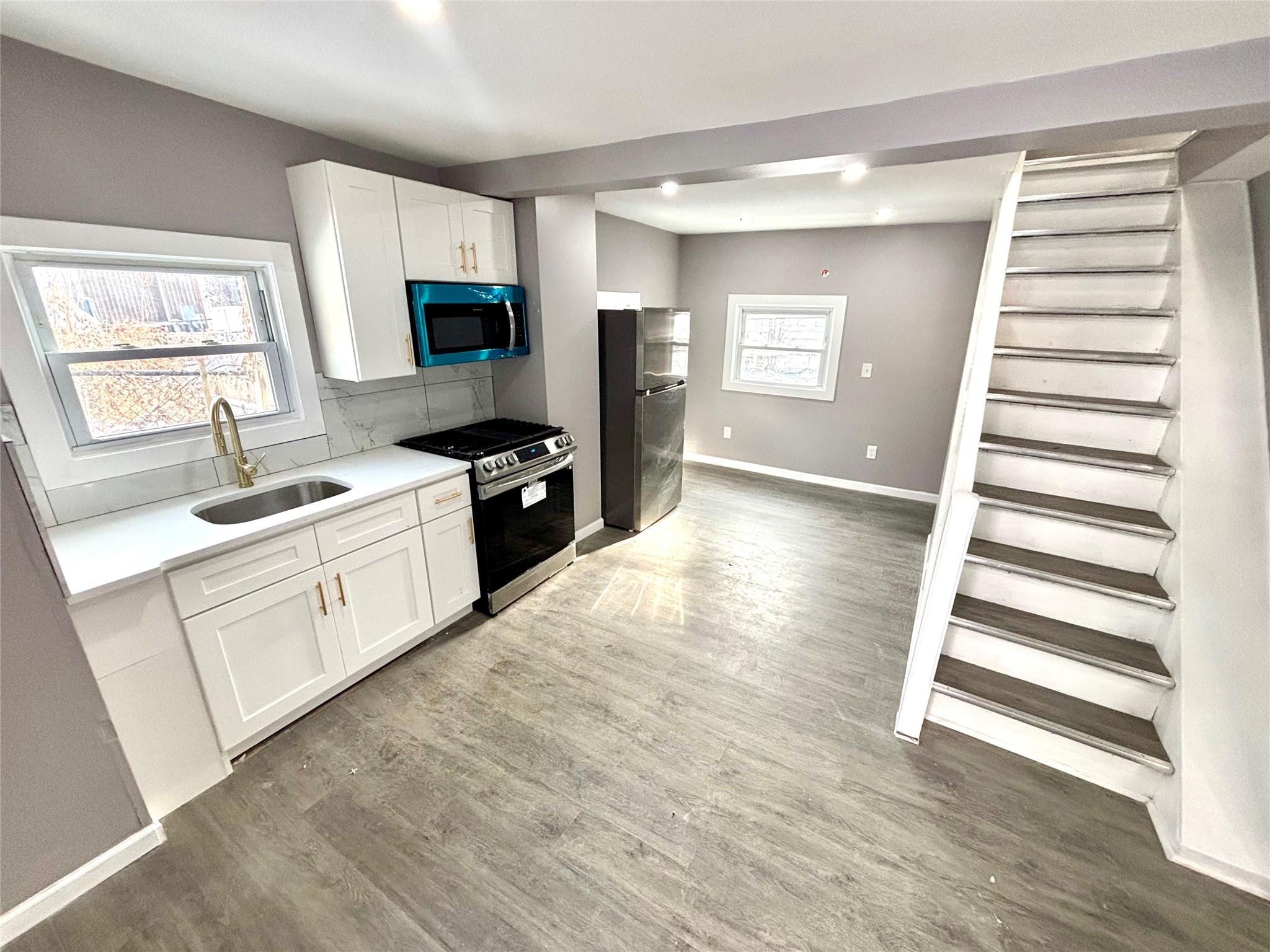 a kitchen with white cabinets and appliances