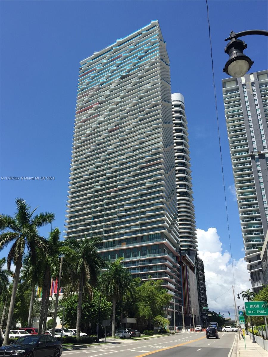 a front view of a building with palm trees