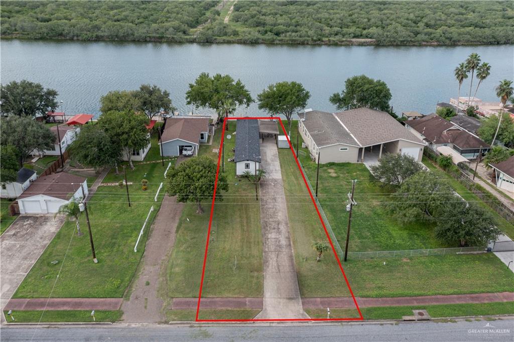 an aerial view of residential houses with outdoor space and lake view