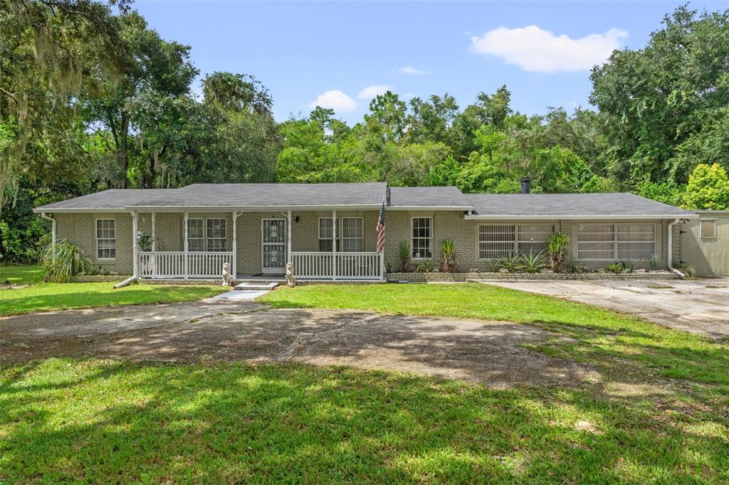 a view of a house with a yard and sitting area