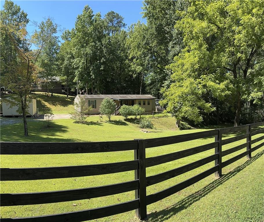 a view of a green yard with large trees