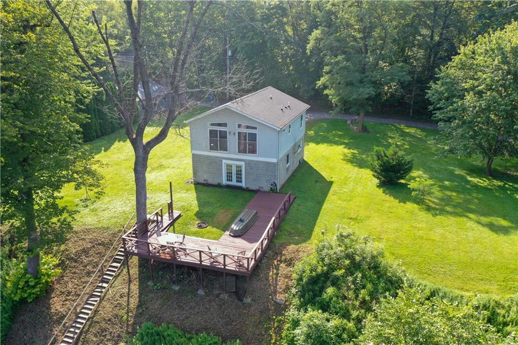 a aerial view of a house with swimming pool and large trees