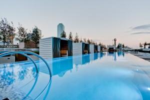 a view of a swimming pool with outdoor seating and trees in the background