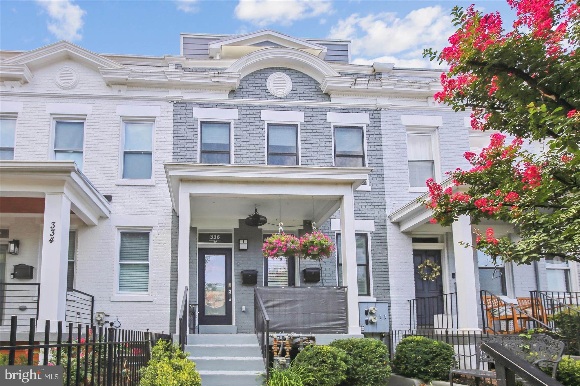 a front view of a house with a lot of flowers