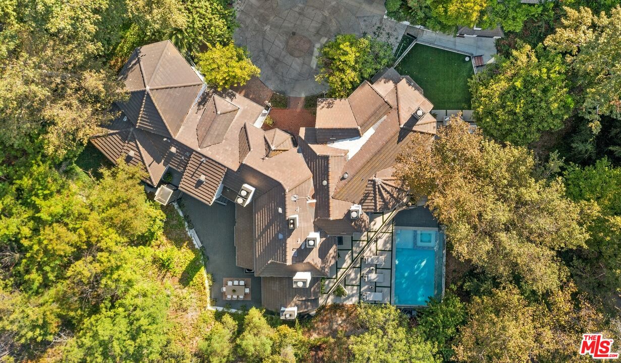 a aerial view of a house with large trees and plants