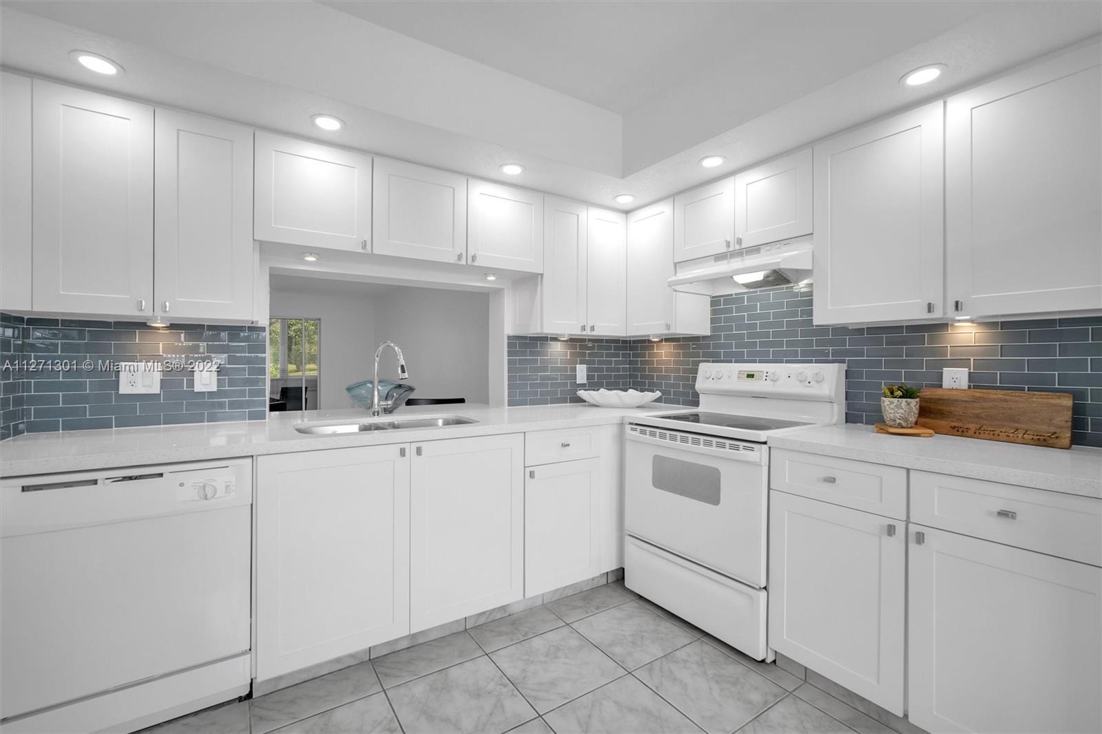 a kitchen with cabinets appliances a sink and a counter top space