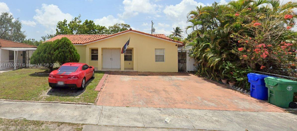 a yellow and red car sitting in front of a house