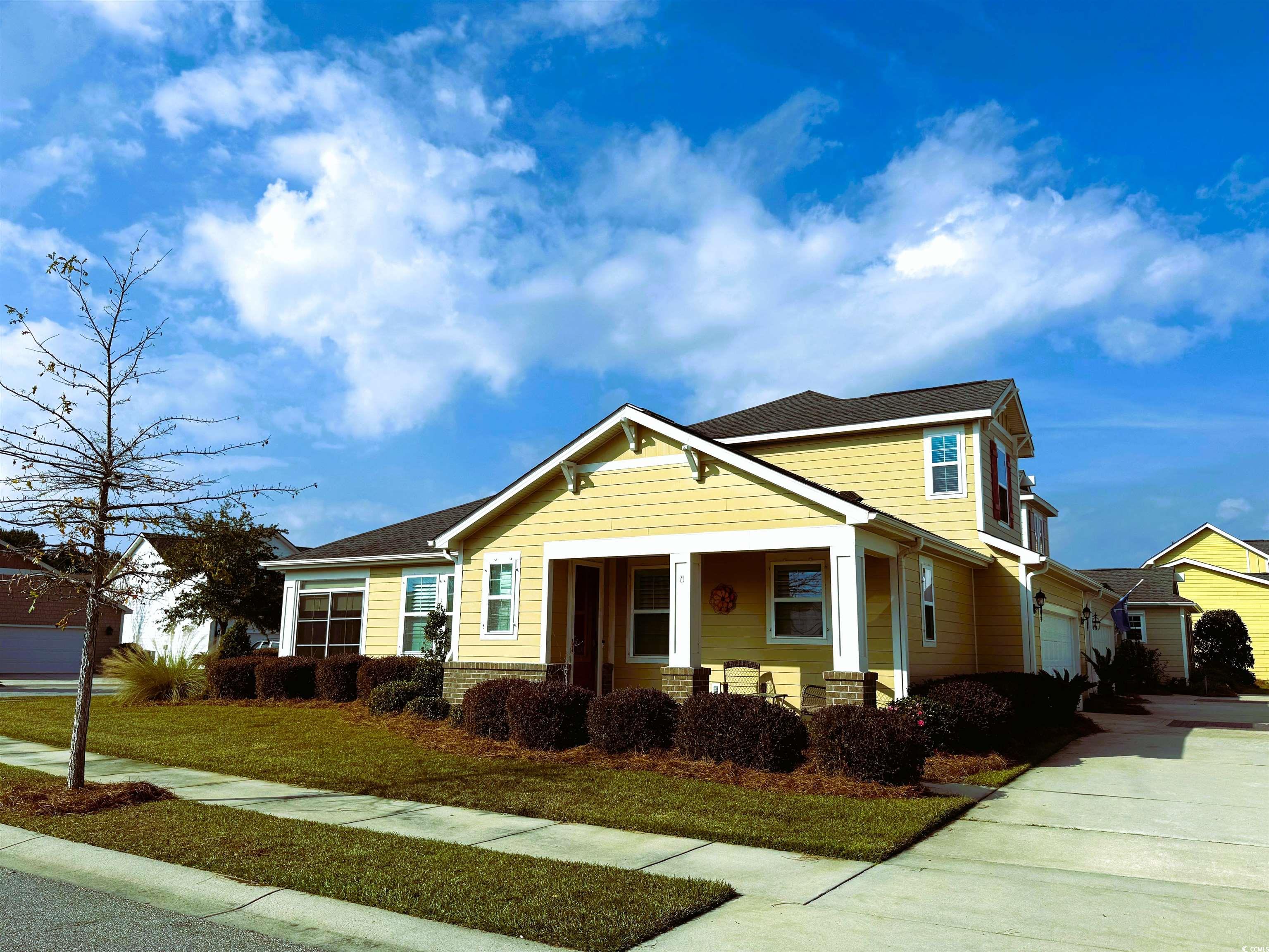 View of front facade featuring a front lawn, a por