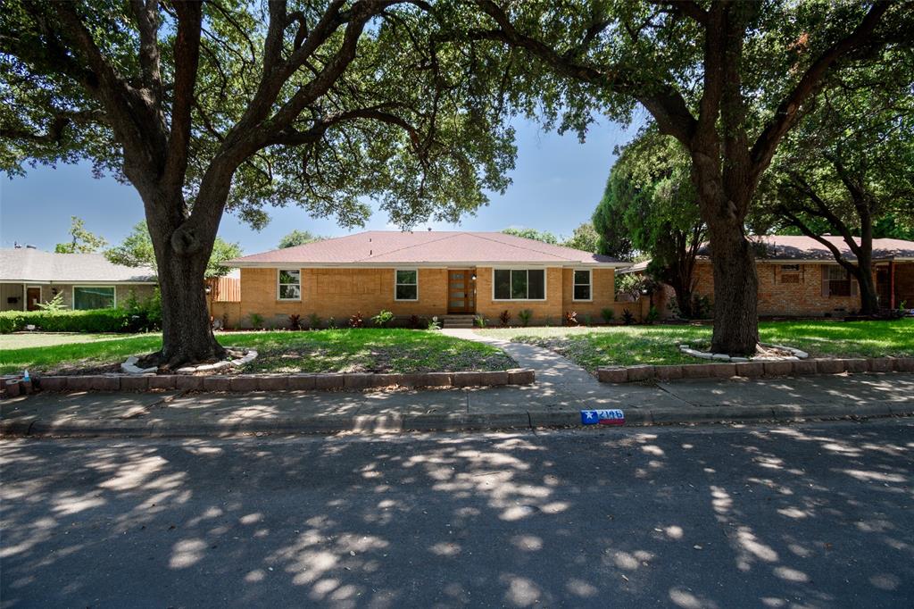 a front view of a house with a yard and tree s