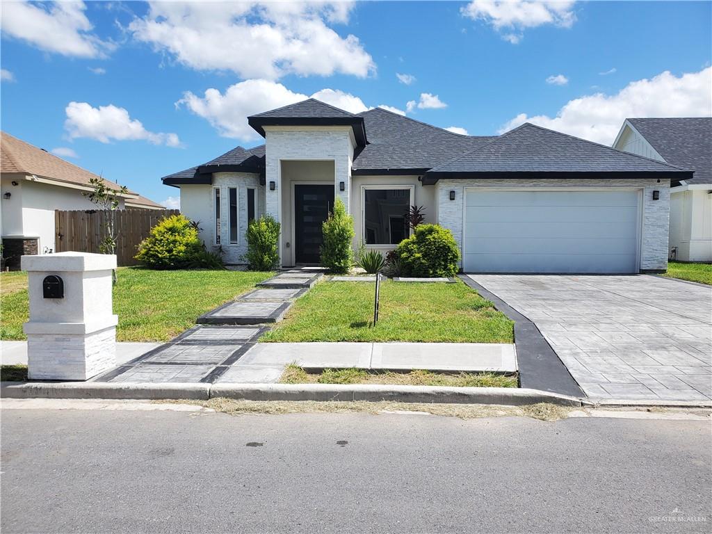 a front view of a house with a yard and garage