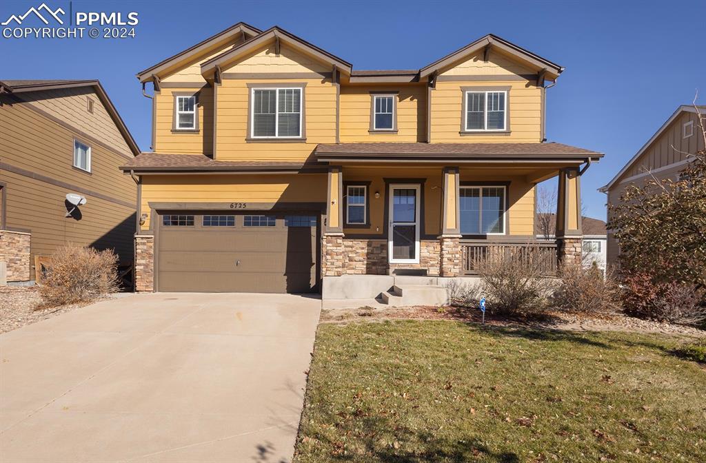 Craftsman-style house with a front yard, a porch, and a garage