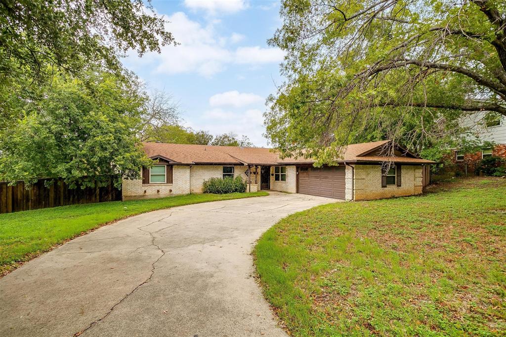 a front view of a house with a yard and trees