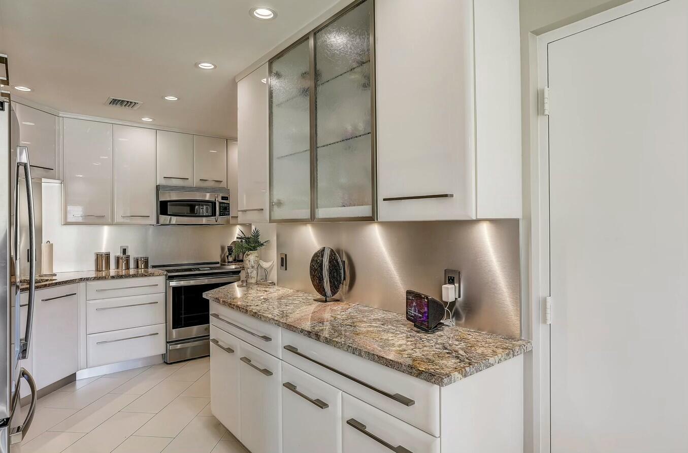 a kitchen with stainless steel appliances granite countertop a sink stove and refrigerator