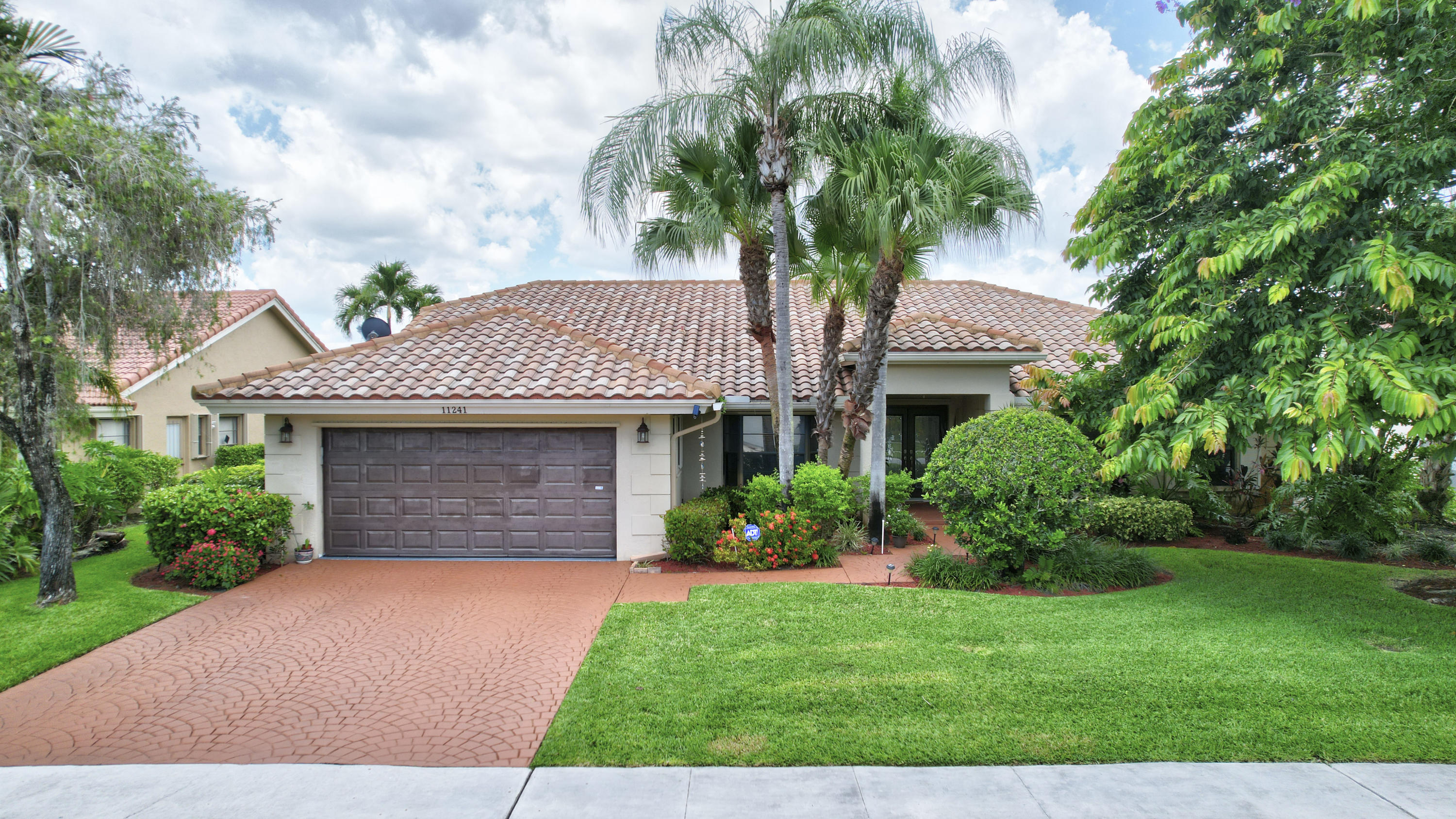 a front view of a house with a garden and plants