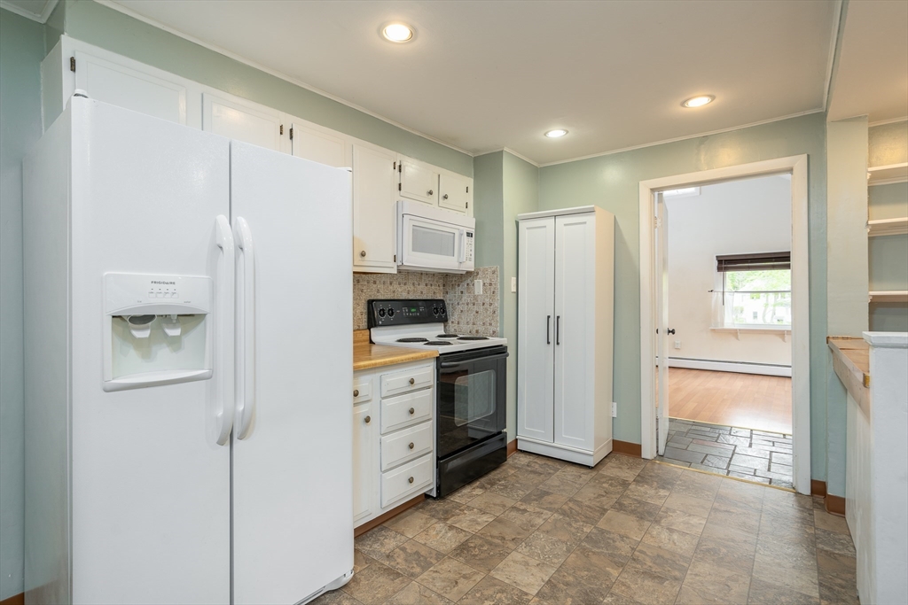 a kitchen with cabinets and a refrigerator