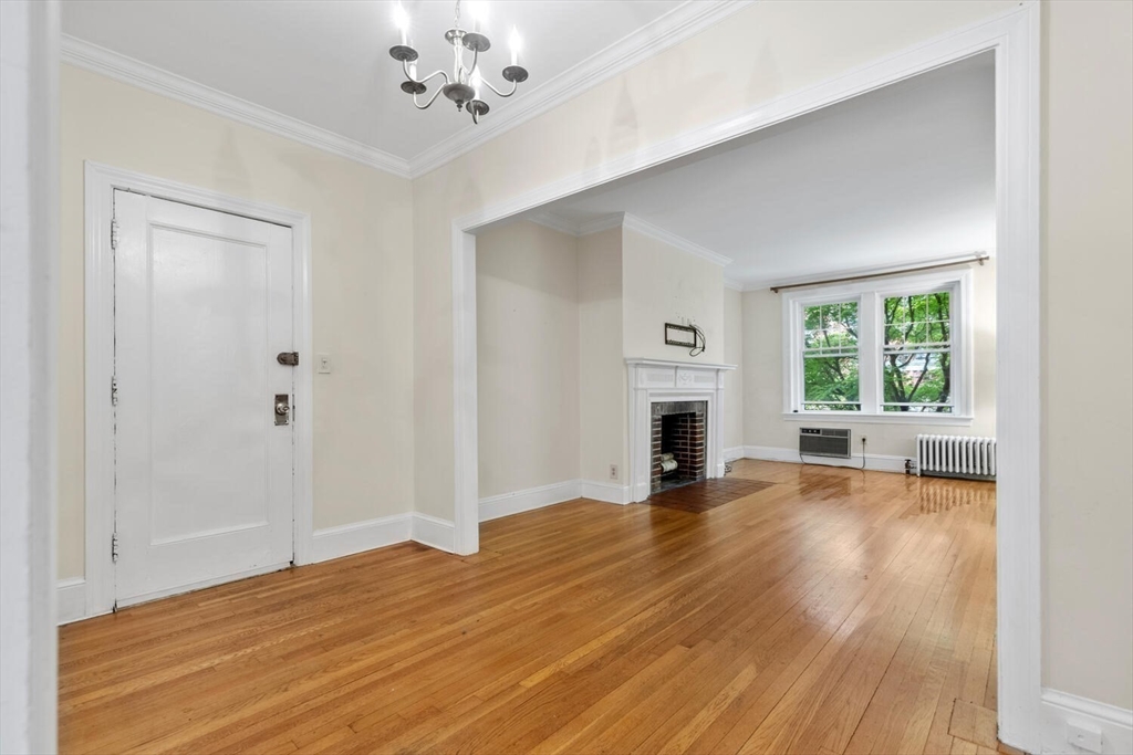 a view of empty room with fireplace and wooden floor