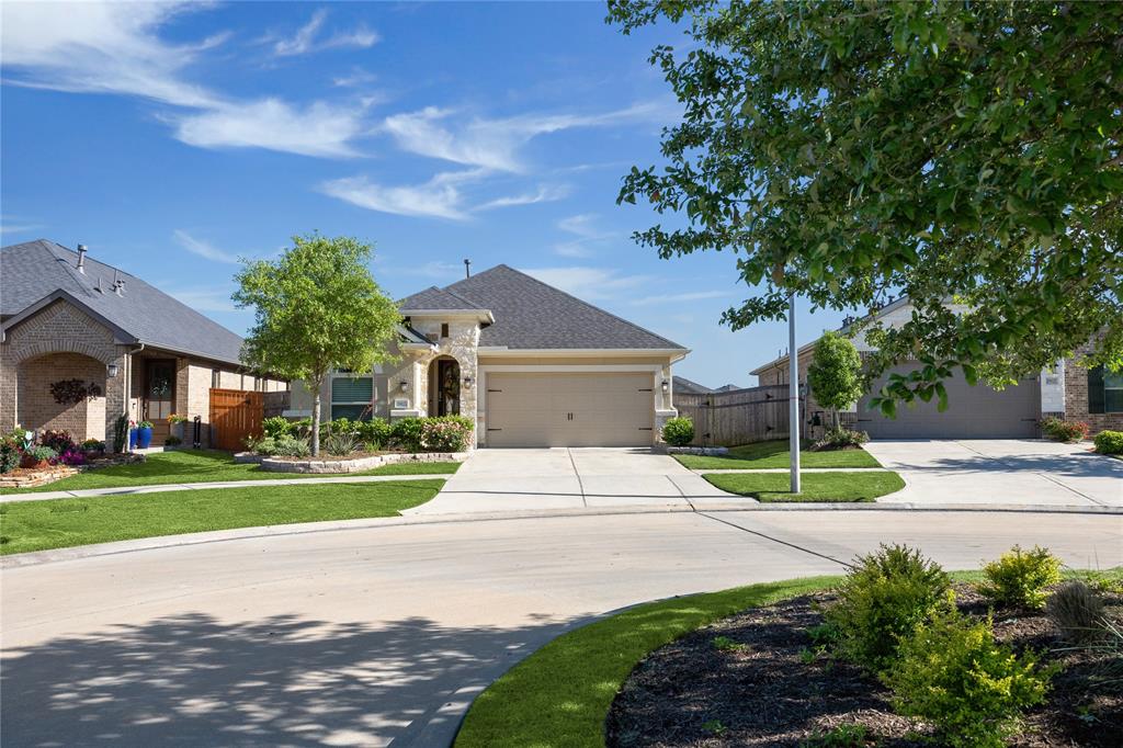 a front view of a house with a yard and trees