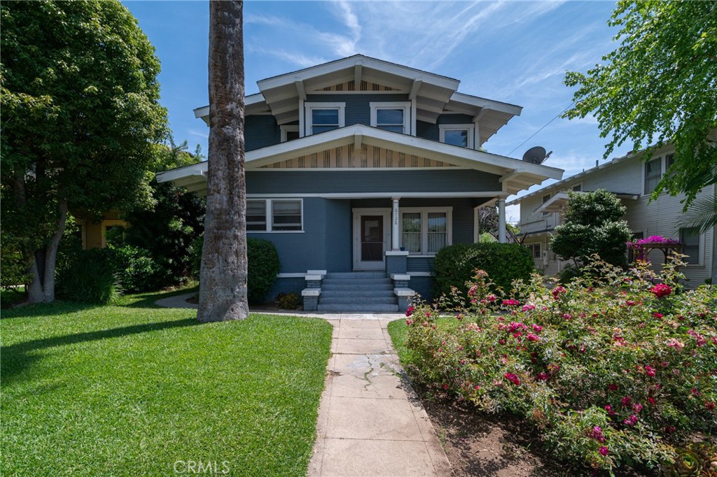 a front view of a house with a yard and potted plants