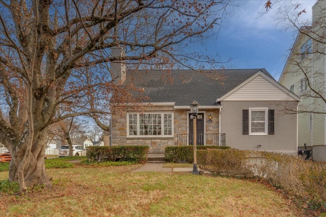 View of front of home with a front lawn and cooling unit