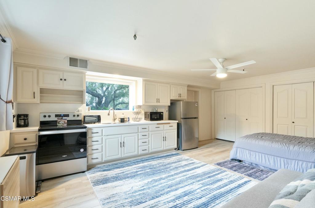 a large kitchen with a stove sink and cabinets