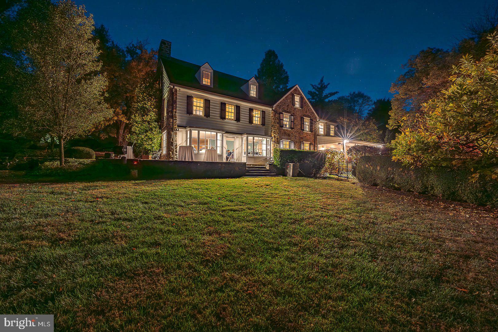 a view of a big house with a big yard and large trees