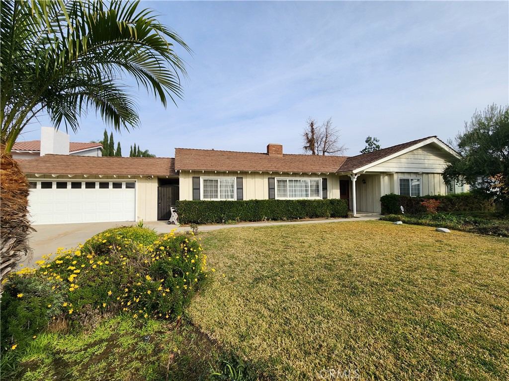 a front view of house with yard and trees in the background