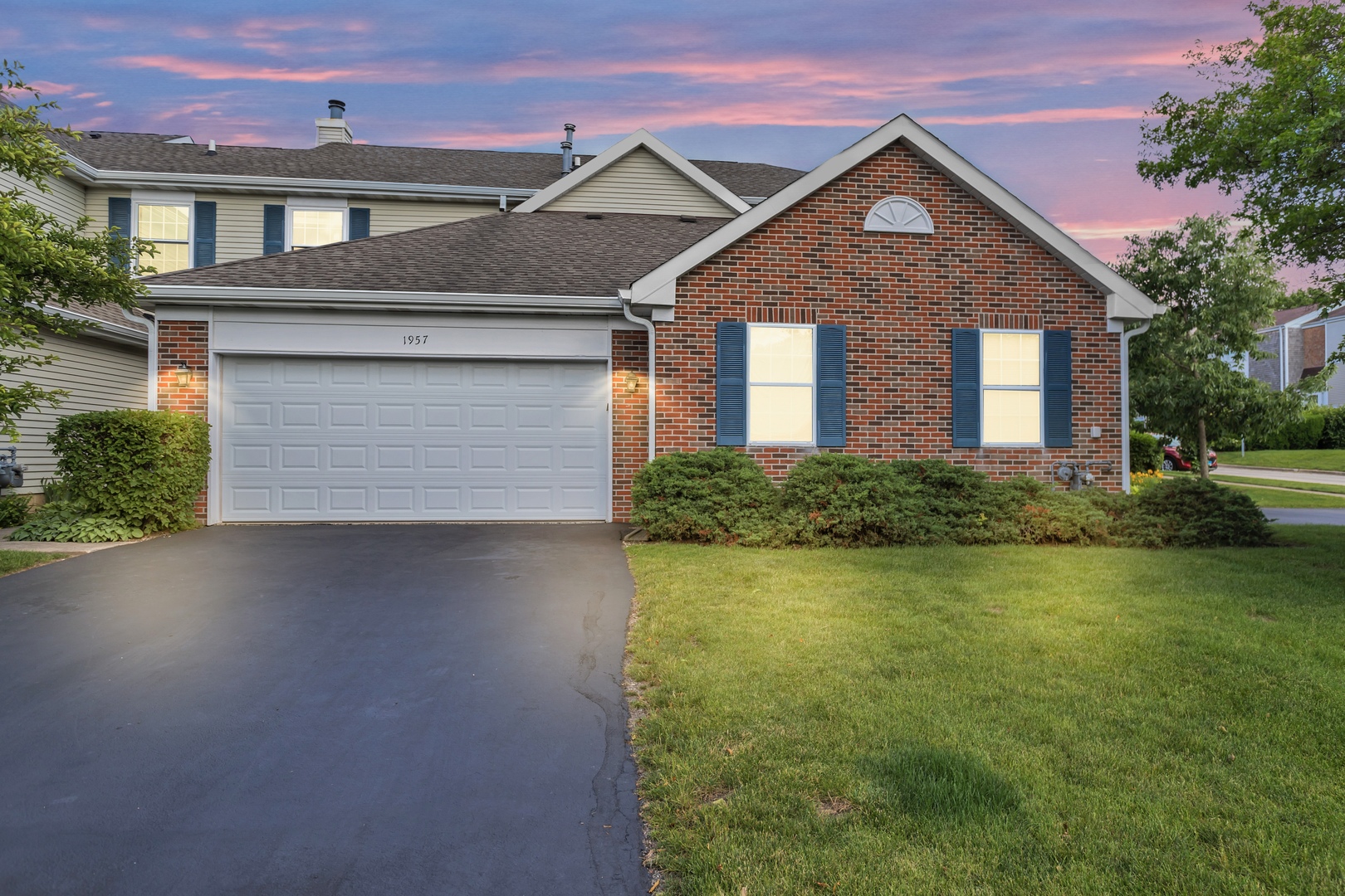 a front view of a house with a yard and garage