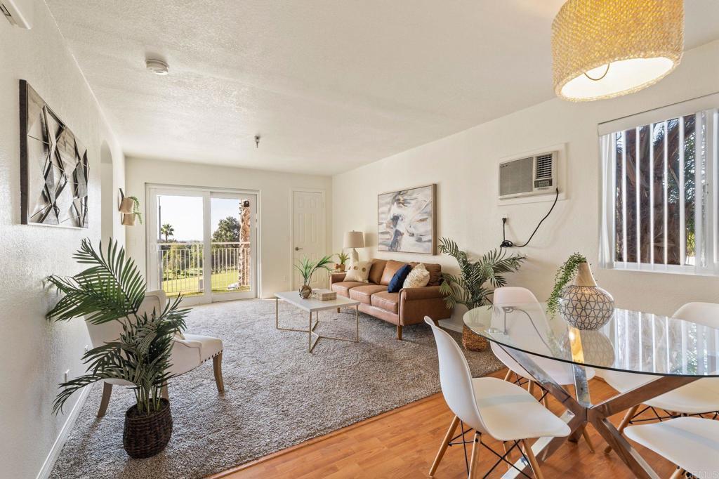 a living room with furniture floor to ceiling window and a potted plant