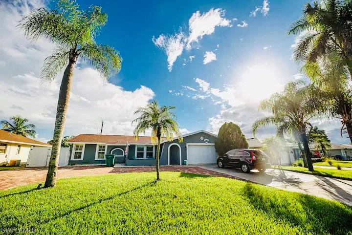 Single story home featuring a front lawn and a garage