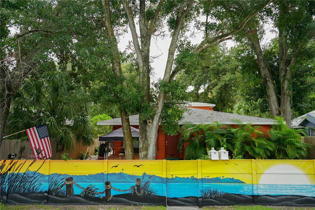 a view of swimming pool with lawn chairs and large trees