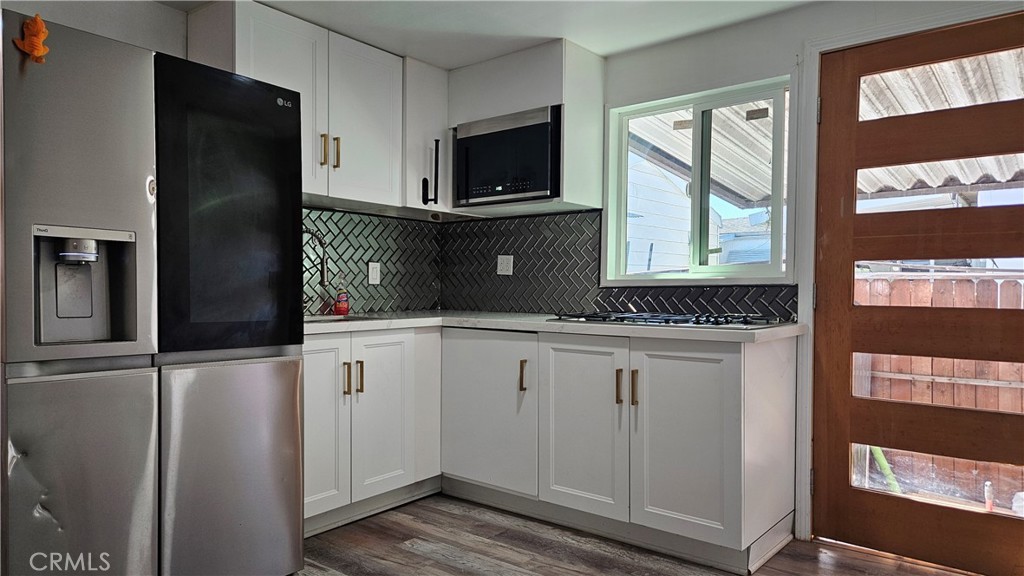 a kitchen with stainless steel appliances granite countertop a refrigerator and a stove