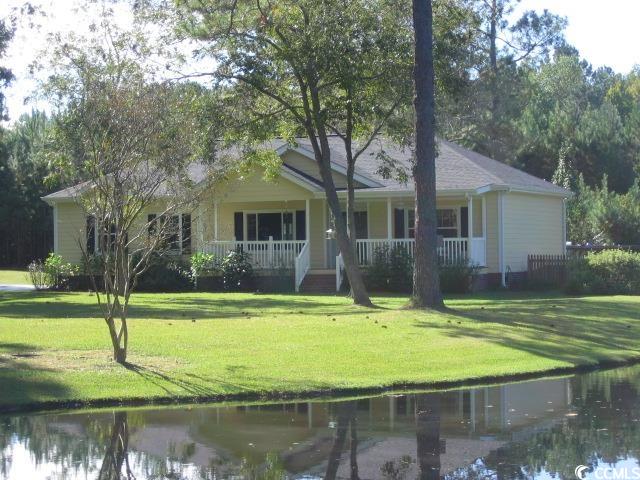 Ranch-style home featuring a water view, covered p