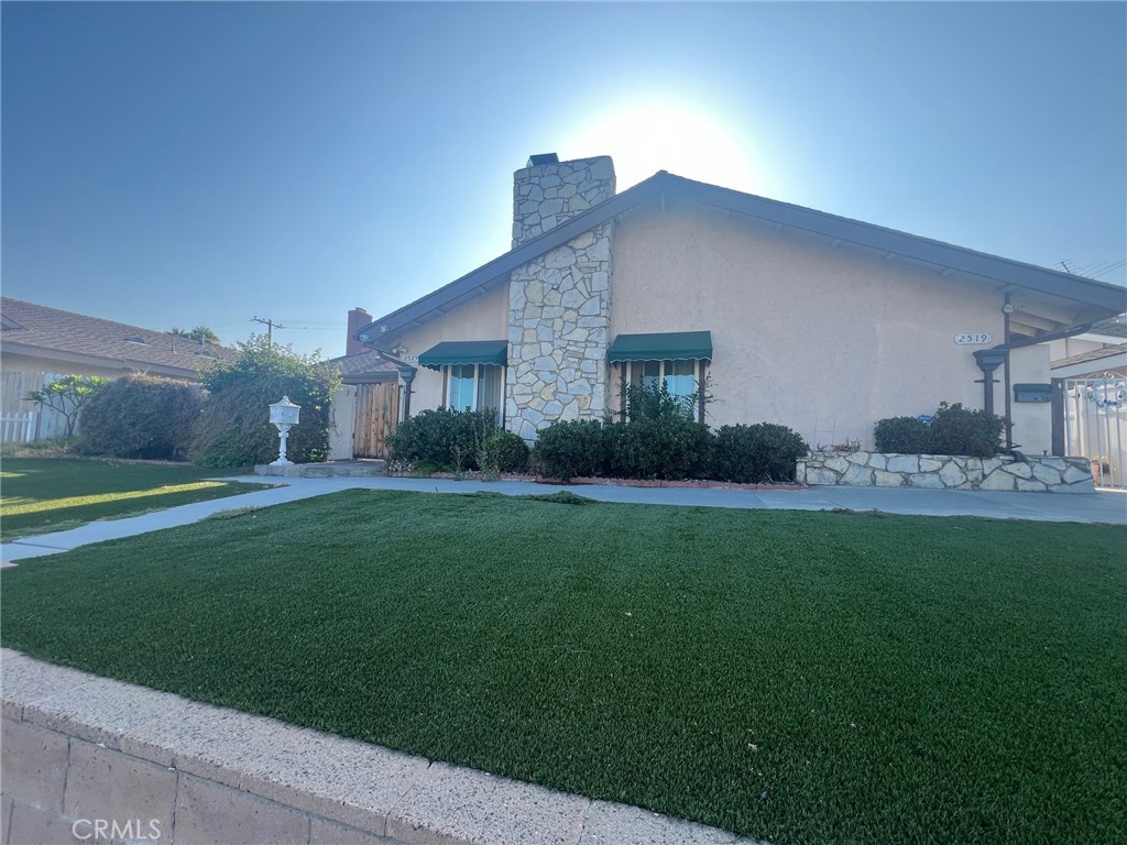 a view of a house with a yard and potted plants