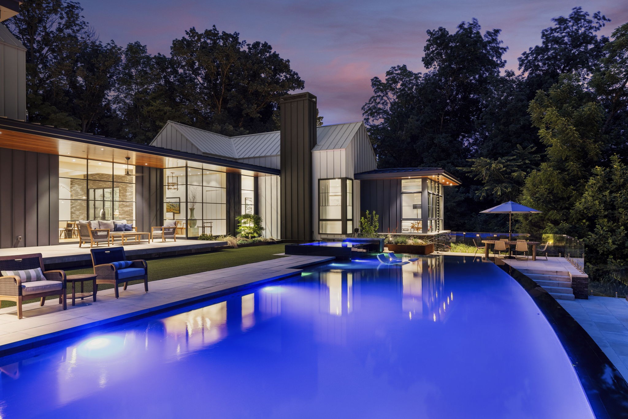 a swimming pool with outdoor seating and yard in the back