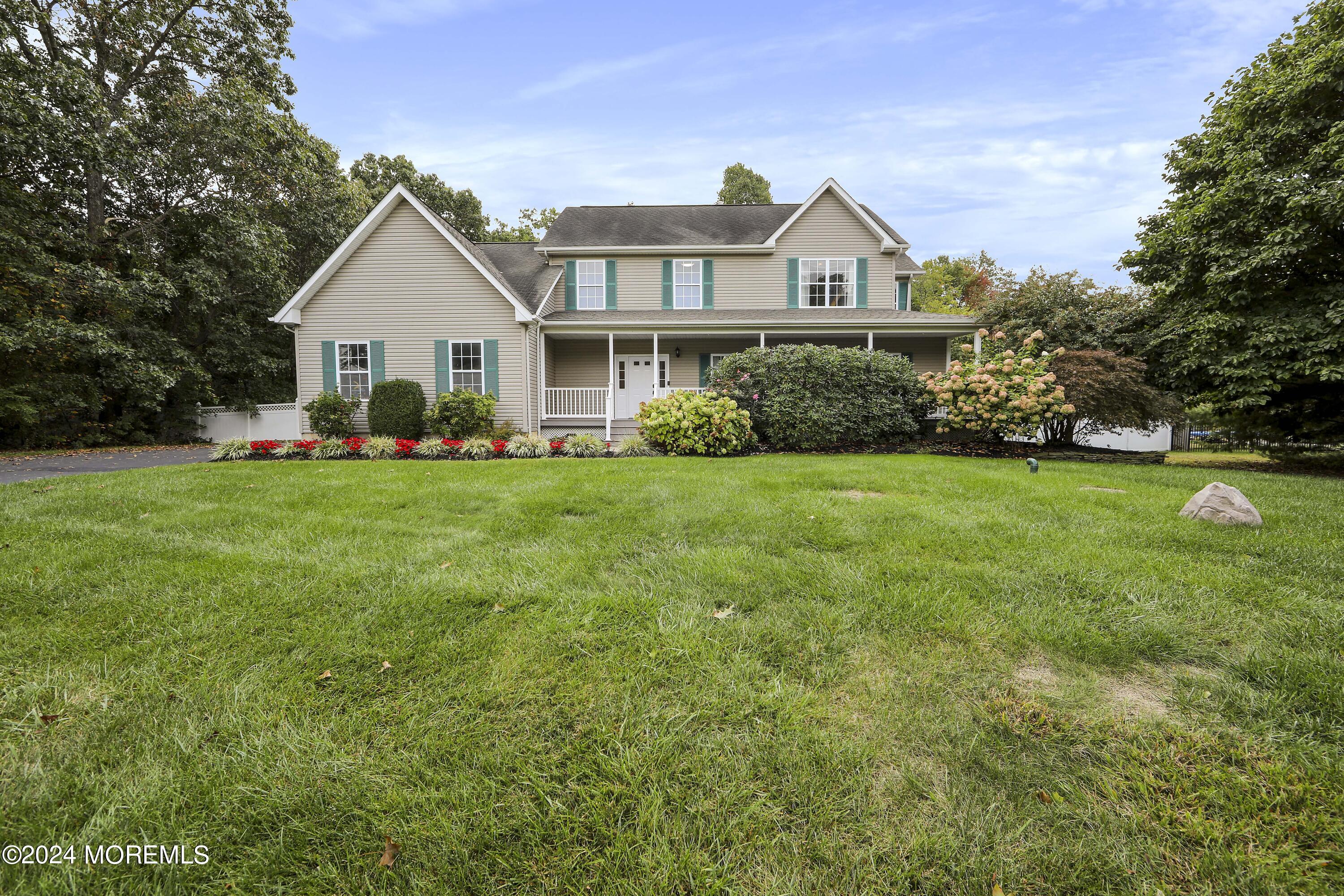 a front view of a house with a yard and trees