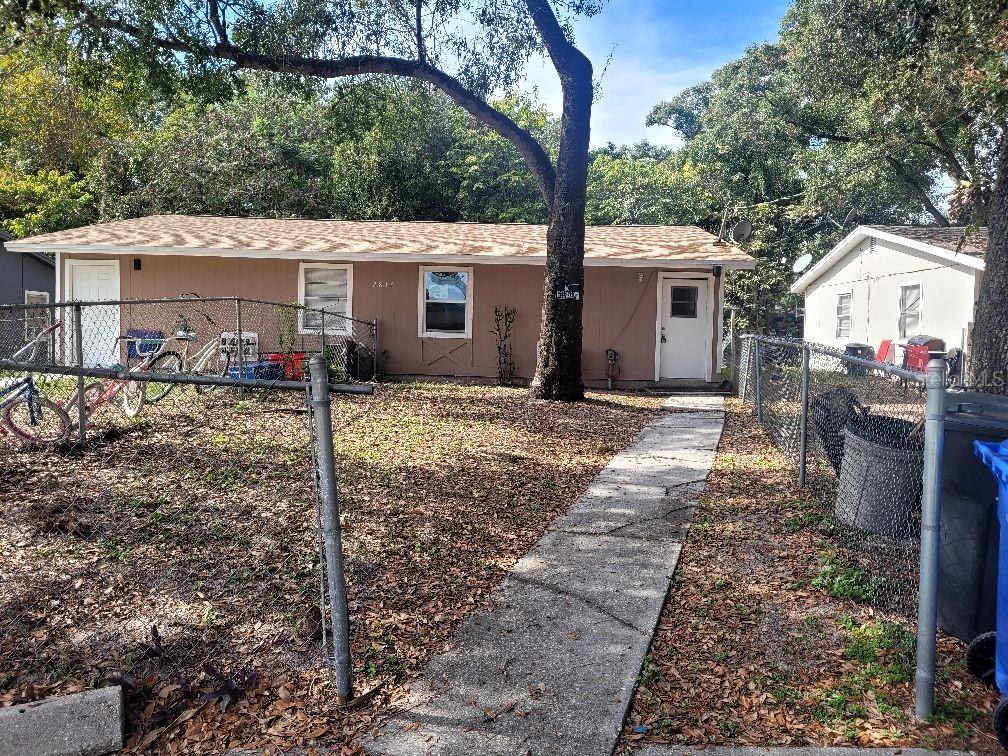 a view of a house with a yard and large tree