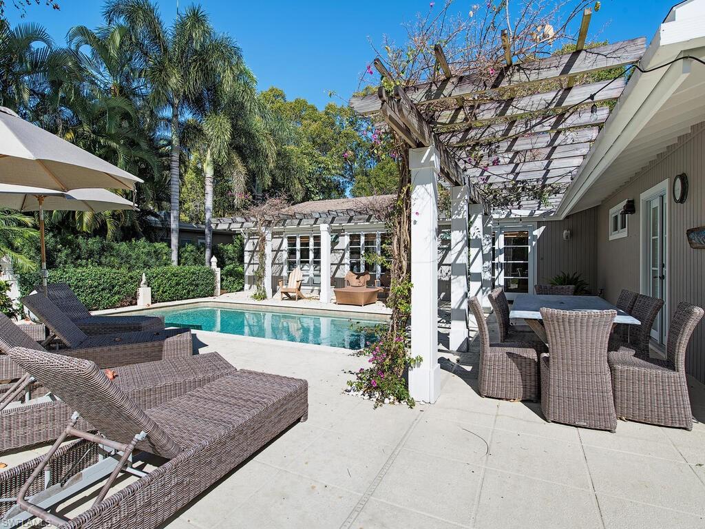 a view of a patio with couches table and chairs and potted plants