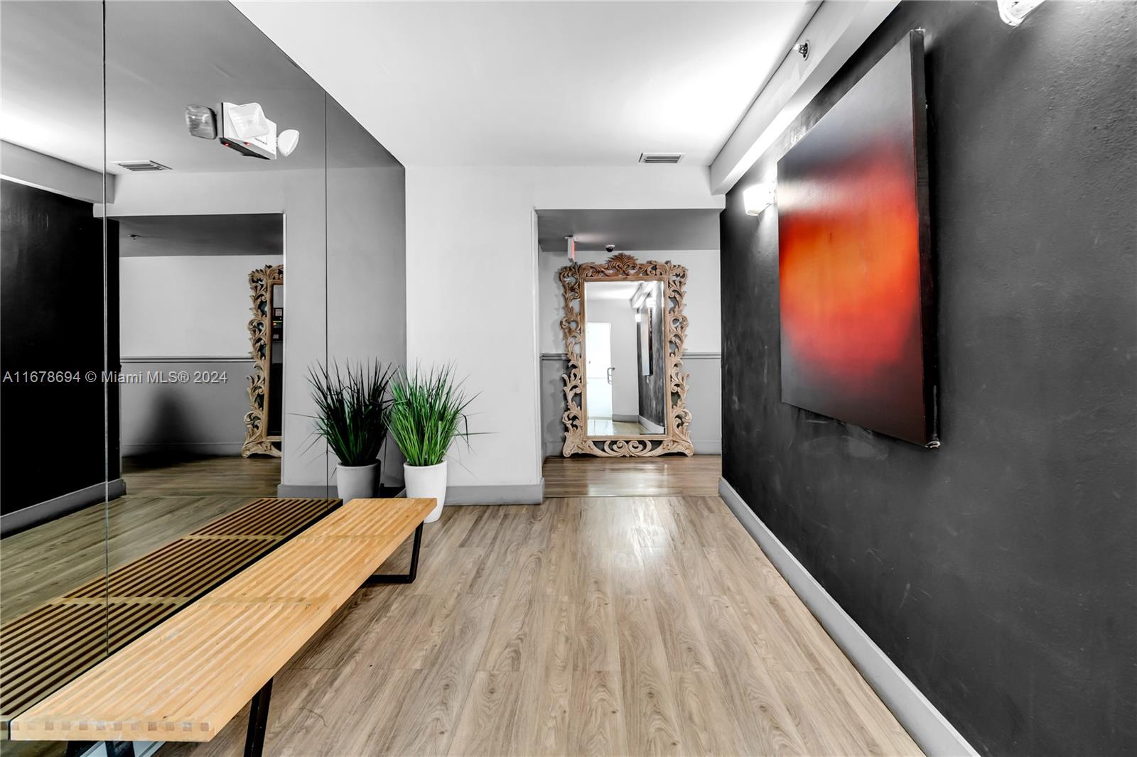 a view of a hallway with wooden floor and a flat screen tv