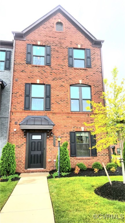 a front view of a house with a yard and plants