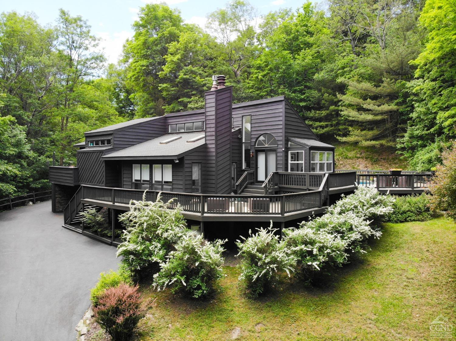 a front view of a house with a small yard and a large tree