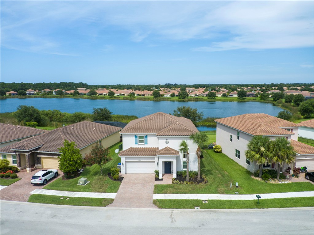 an aerial view of a house with a garden and lake view