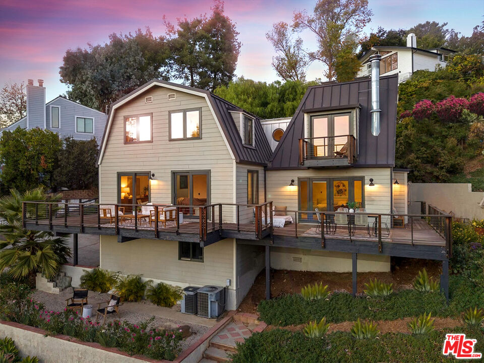 a front view of a house with garden and lake view