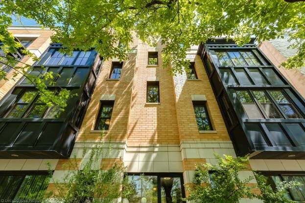 a view of a multi story residential apartment building with a yard