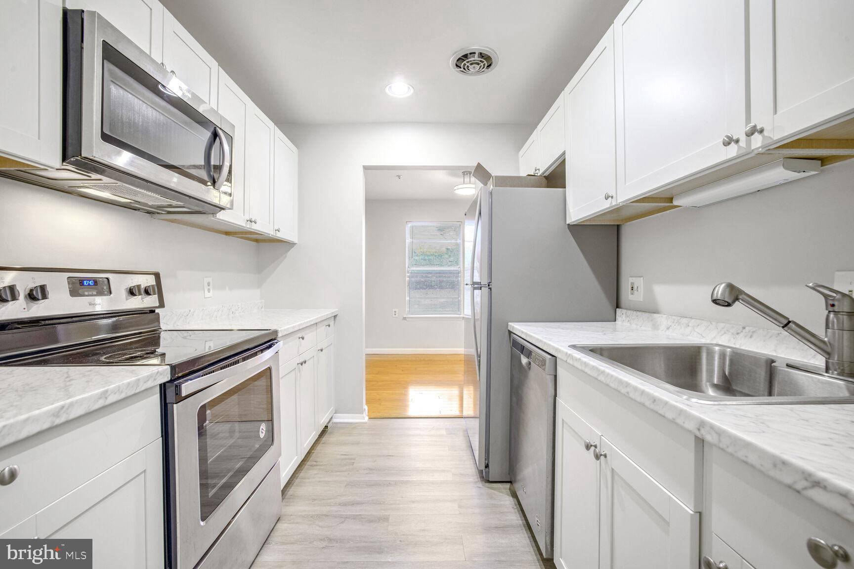 a kitchen with stainless steel appliances granite countertop a sink and a stove